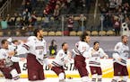 University of Massachusetts men's hockey players rush onto the ice to celebrate after defeating St. Cloud State 5-0 to claim the program's first natio