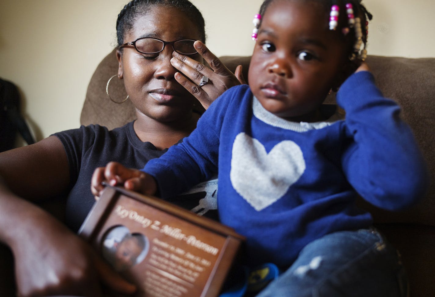 On October 3, 2014 in St. Paul. Ashia Miller holds the urn of her nephew Ke'Ontay while her youngest child, Julianna,2 sits on her. She reported to child protection several times that Key'ontay was being abused by William Warr, a convicted felon. Counties responded by opening family assessment cases. Key'ontay died last year, and Warr is charged with his murder.]Richard Tsong-Taatarii/rtsong- taatarii@startribune.com ORG XMIT: MIN1410051256461119