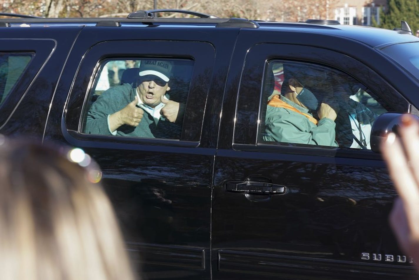 President Donald Trump gives two thumbs up to supporters as he departs after playing golf at the Trump National Golf Club in Sterling Va., Sunday Nov. 8, 2020.