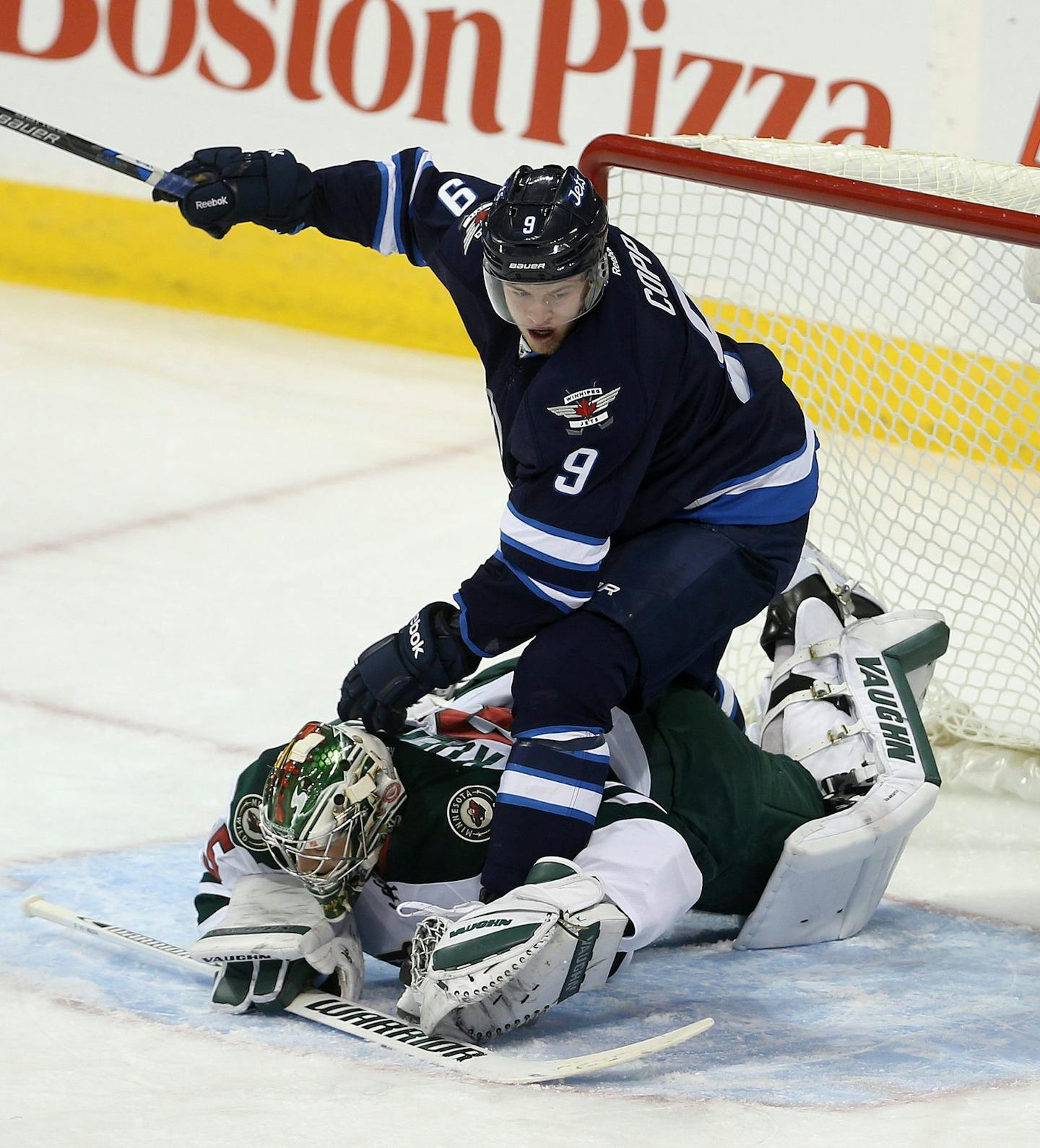 Winnipeg Jets' Andrew Copp (9) gets tangled up with Minnesota Wild goaltender Darcy Kuemper (35) during first period NHL hockey action in Winnipeg, Sunday, Oct. 25, 2015. (Trevor Hagan/The Canadian Press via AP)