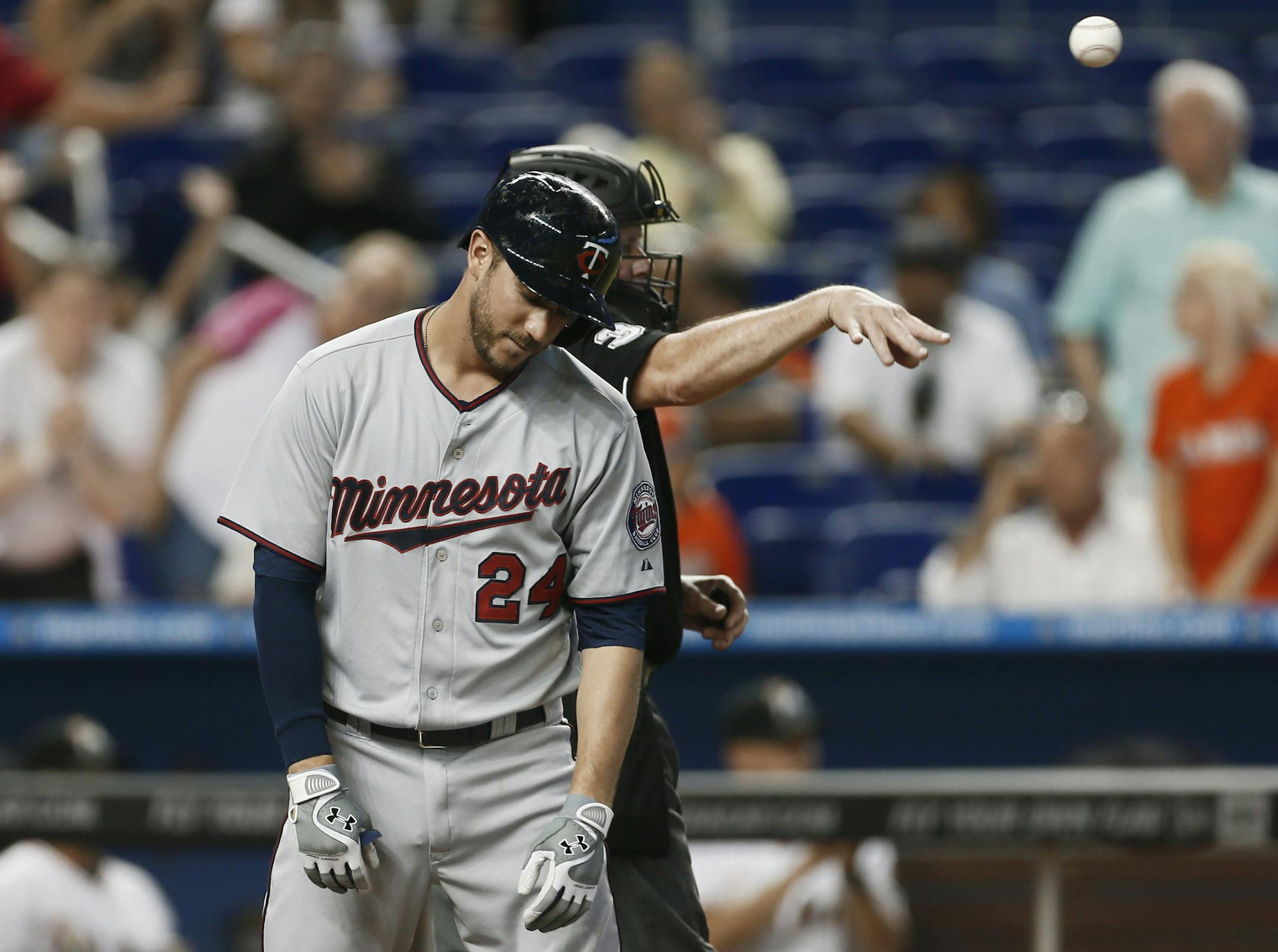 Minnesota Twins' Trevor Plouffe (24) reacts after striking out to end the top of the seventh inning of a baseball game against the Miami Marlins, Wednesday, June 26, 2013, in Miami. Home plate umpire Tim Welke throws the ball back to the pitcher. The Marlins won 5-3. (AP Photo/J Pat Carter)