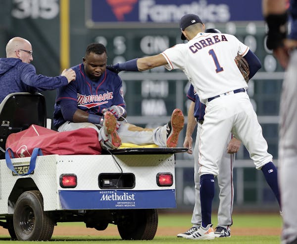Minnesota Twins designated hitter Miguel Sano gets a pat on the back from Houston Astros shortstop Carlos Correa (1) as he is taken off the field afte