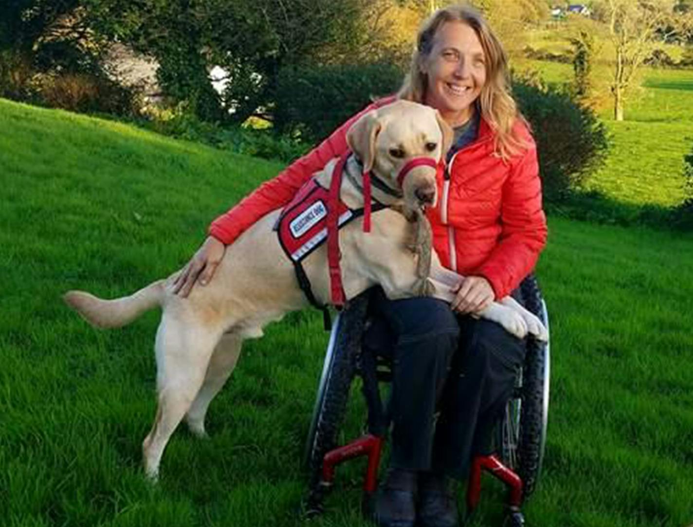 Chris Slavin of Danvers, Massachusetts, with her 3-year-old service dog, Earle. Massachusetts is considering a bill that would crack down on people who misrepresent their pets as service dogs. Nineteen other states have adopted similar measures. (Chris Slavin)