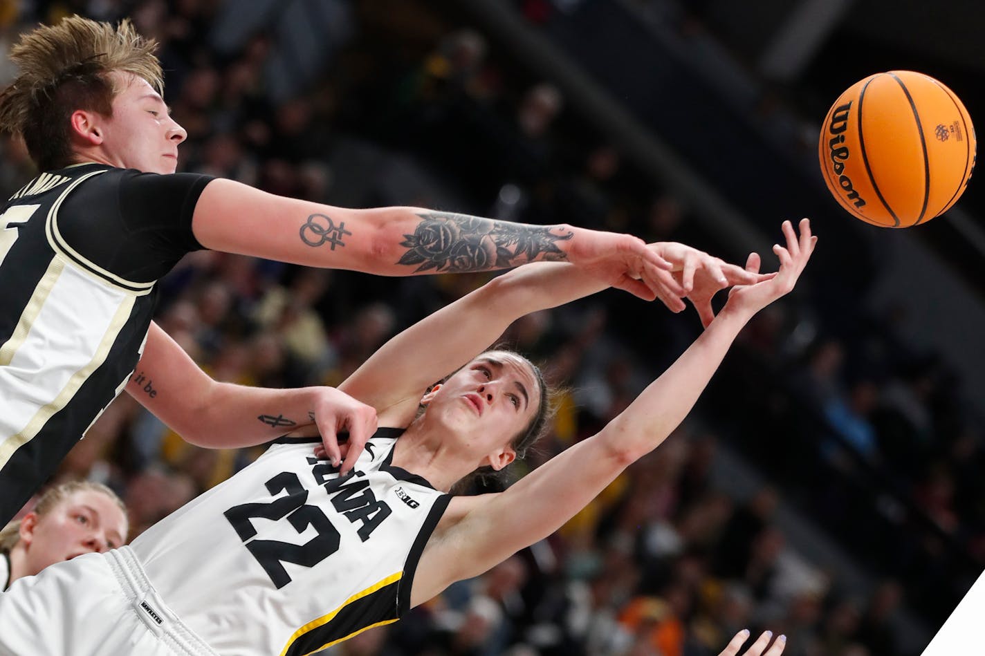 Purdue forward Rickie Woltman, left, knocks the ball away from Iowa guard Caitlin Clark (22) during the first half of an NCAA college basketball game at the Big Ten women's tournament Friday, March 3, 2023, in Minneapolis. (AP Photo/Bruce Kluckhohn)