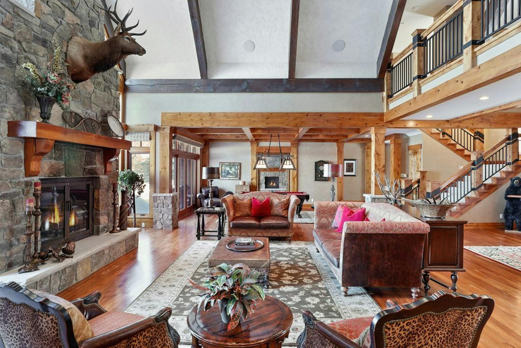 The great room has a two-story vaulted cathedral ceiling and a stone fireplace.