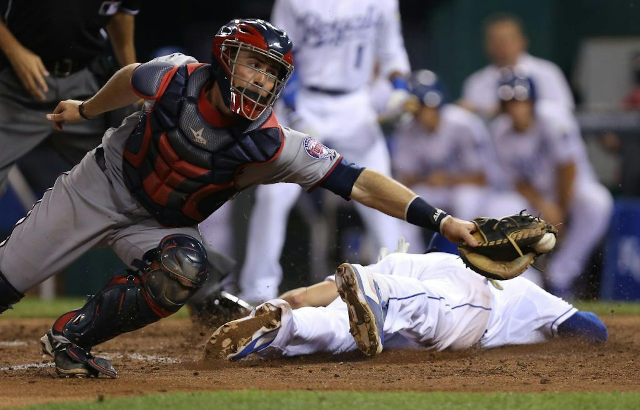 Kansas City Royals' Mike Moustakas dives past Minnesota Twins catcher Eric Fryer (26) as he scores on an Alcides Escobar triple in the seventh inning during a baseball game Thursday, July 31, 2014, in Kansas City, Mo.