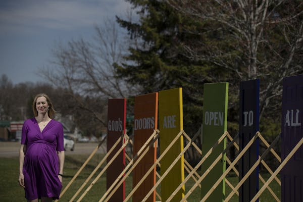 Rev. Brooke Heerwald Steiner of Excelsior United Methodist Church posed with a series of six rainbow colored doors on its lawn Thursday April 25, 2019