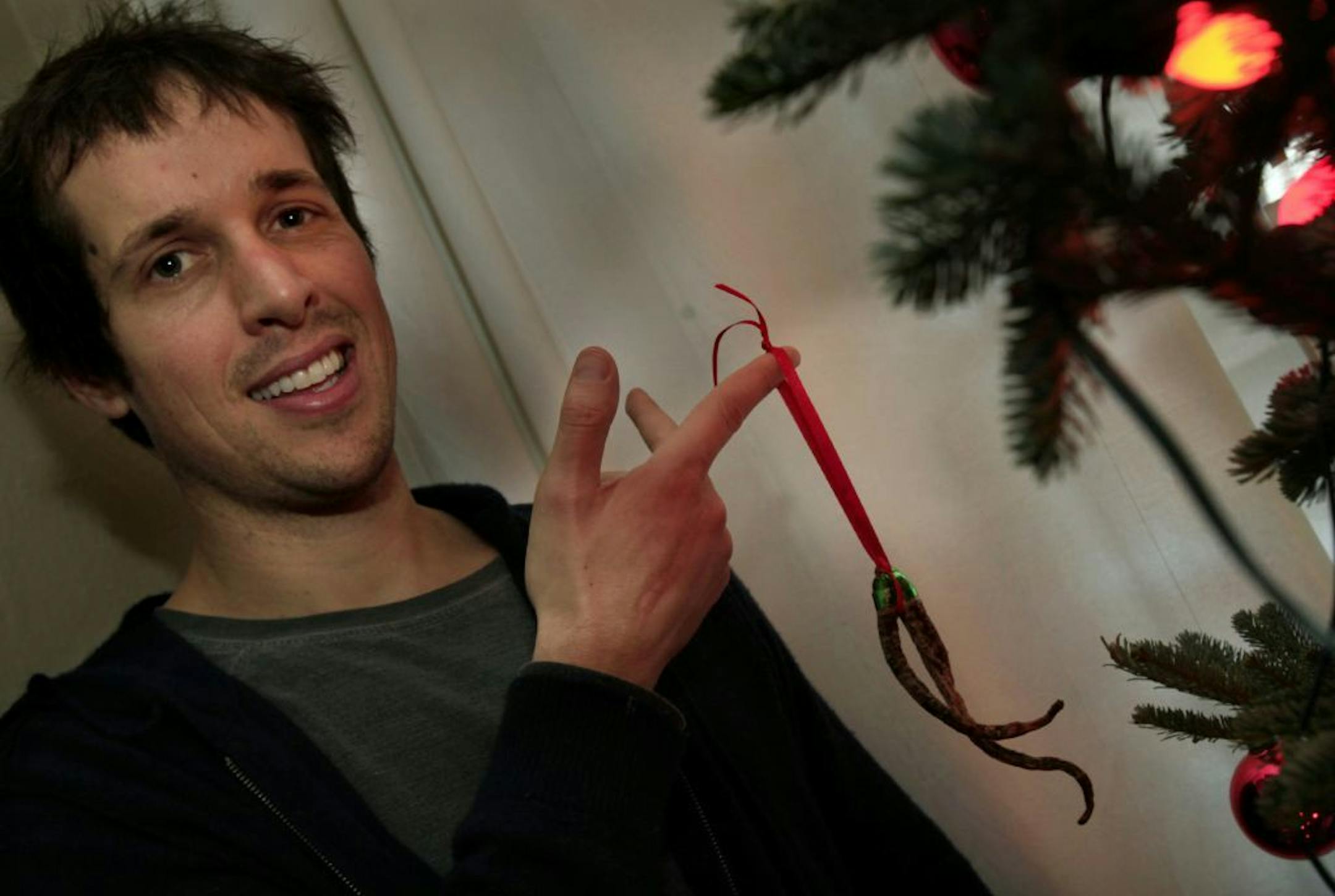 Steve Peck hangs on his tree the ornament his mother made of petrified carrots she found in his dorm fridge while cleaning it years ago. Minneapolis, MN on December 14, 2012.