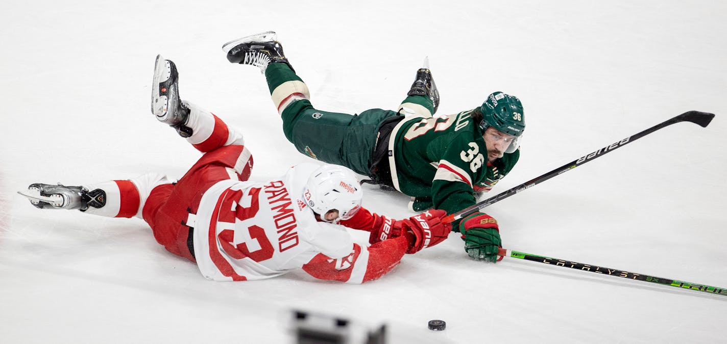 Lucas Raymond (23) of the Detroit Red Wings and Matts Zuccarello (36) of the Minnesota Wild fight for the puck in the third period Monday, Feb. 14, at Xcel Energy Center in St. Paul, Minn. ] CARLOS GONZALEZ • cgonzalez@startribune.com