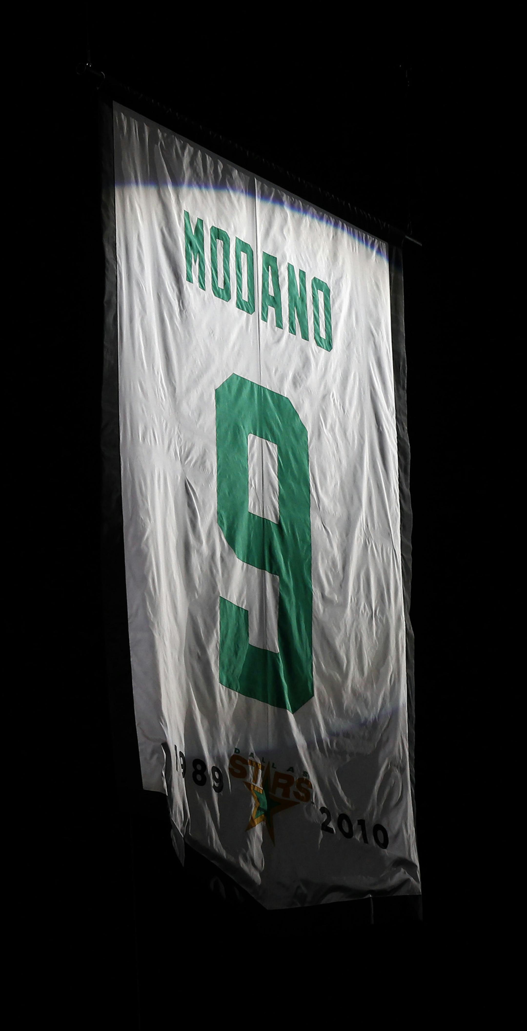 Mike Modano's jersey No. 9 is raised during a retirement ceremony before the Dallas Stars played the Minnesota Wild in an NHL hockey game Saturday, March 8, 2014, in Dallas. (AP Photo/The Dallas Morning News, Nathan Hunsinger) MANDATORY CREDIT; MAGS OUT; TV OUT; INTERNET USE BY AP MEMBERS ONLY; NO SALES
