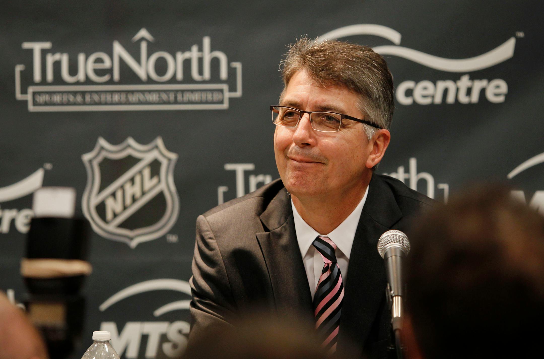Claude Noel smiles as he is introduced as the new head coach of the unnamed Winnipeg NHL franchise during a hockey news conference Friday, June 24, 2011, in Minneapolis. (AP Photo/Genevieve Ross)