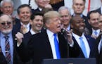 FILE - In this Dec. 20, 2017, file photo, House Speaker Paul Ryan of Wis., back left center, and other lawmakers react as President Donald Trump speak