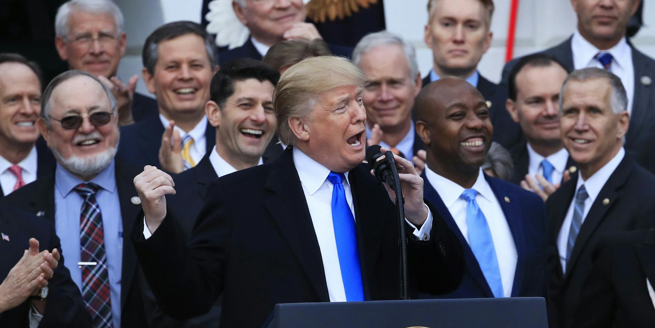 FILE - In this Dec. 20, 2017, file photo, House Speaker Paul Ryan of Wis., back left center, and other lawmakers react as President Donald Trump speaks about the passage of the tax overhaul bill on the South Lawn at the White House in Washington. Trump often brags that heís done more in his first year in office than any other president. Thatís a spectacular stretch. But while heís fallen short on many measures and has a strikingly thin legislative record, Trump has followed throug