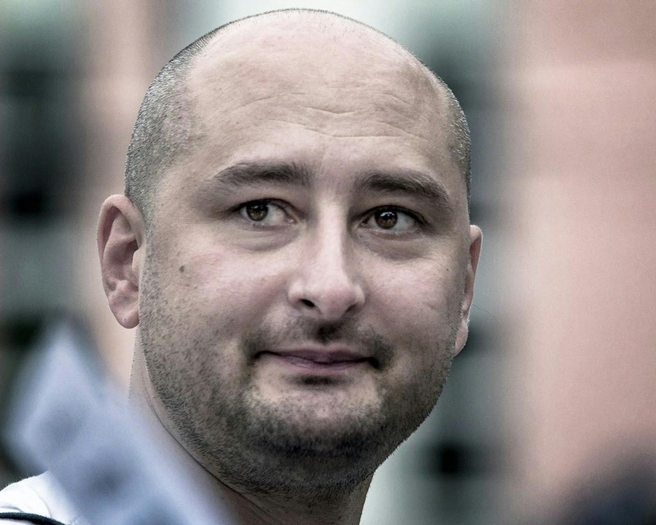 In this photo taken on Friday, Aug. 9, 2013, Arkady Babchenko, 41, who had been scathingly critical of the Kremlin in recent years, looks at an opposition picket in Moscow, Russia.