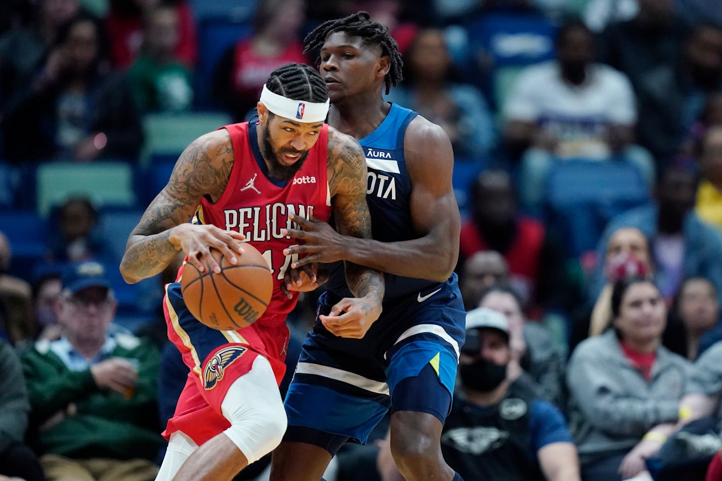 New Orleans Pelicans forward Brandon Ingram drives to the basket against Minnesota Timberwolves forward Anthony Edwards in the first half of an NBA basketball game in New Orleans, Monday, Nov. 22, 2021. (AP Photo/Gerald Herbert)