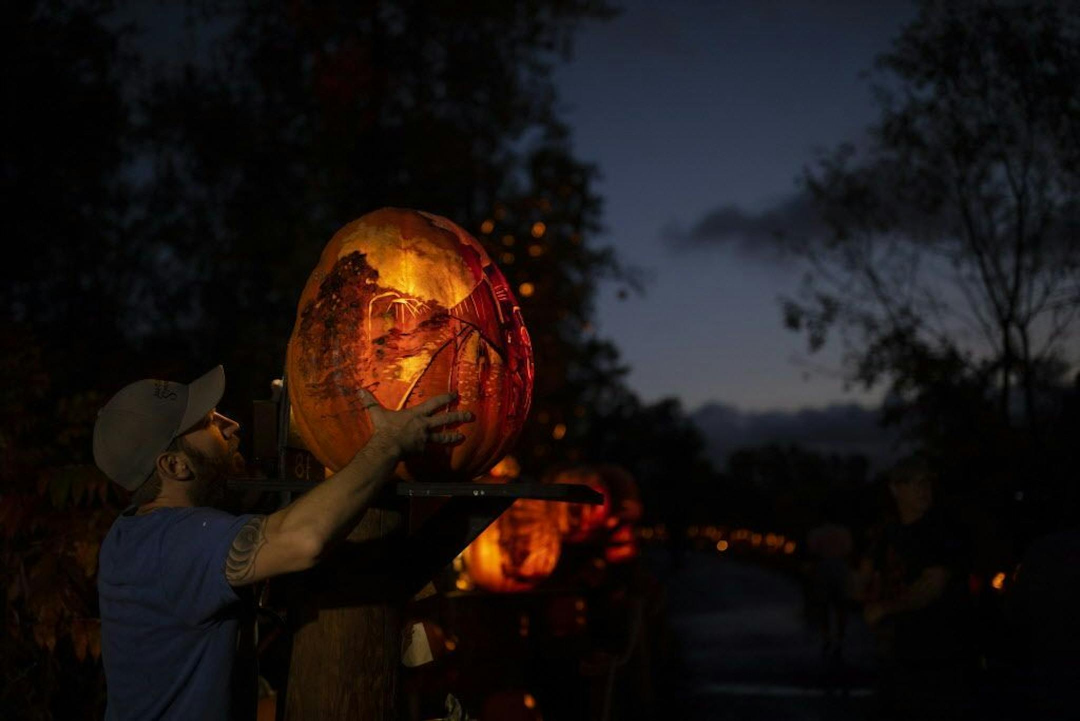 Paul Cadieux positioned one of the 127 "intricate" carved pumpkins after placing a light inside it. It can take as long as eight hours to carve the more elaborate pumpkins.