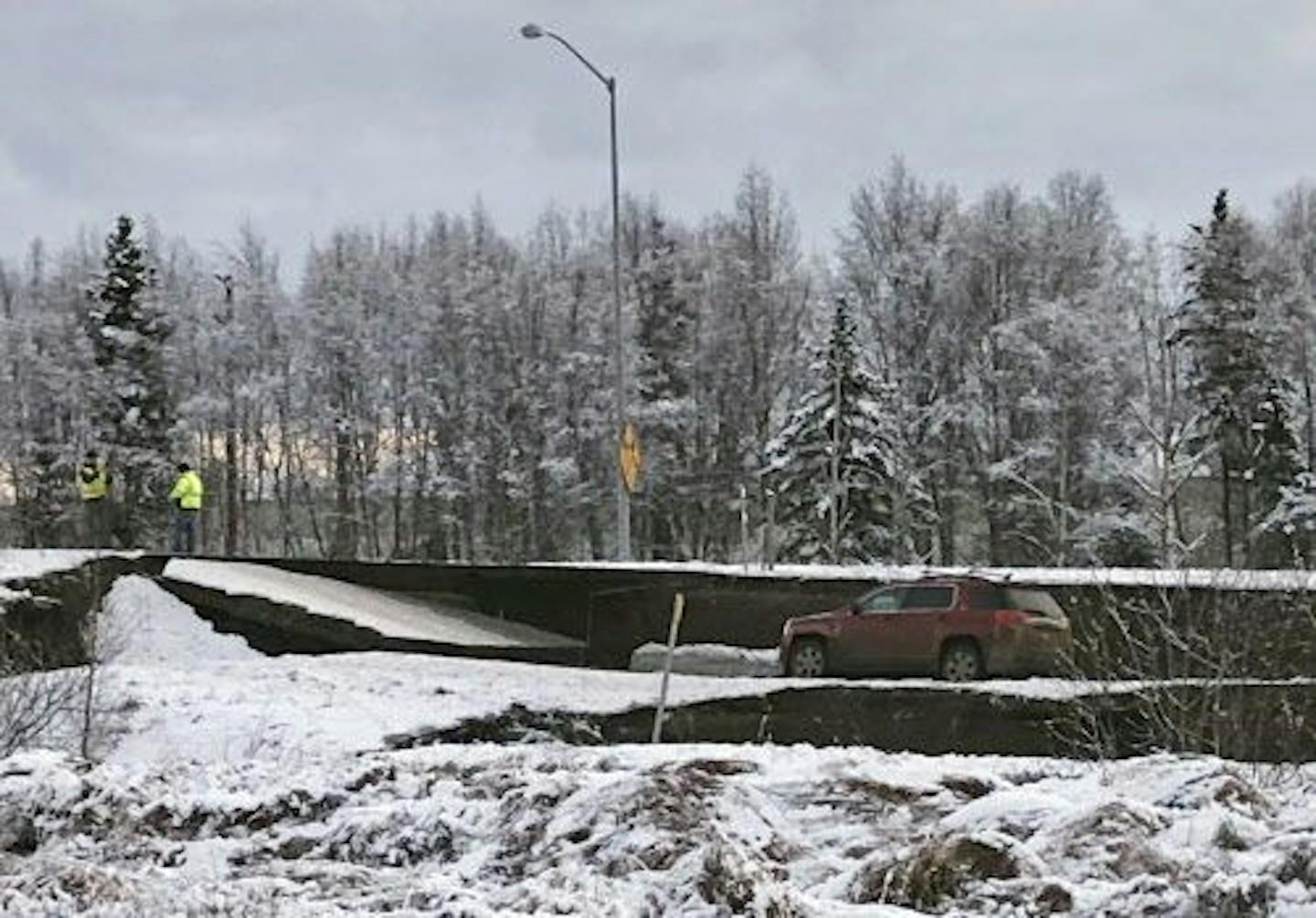 A car is trapped on a collapsed section of the offramp off of Minnesota Drive in Anchorage, Friday, Nov. 30, 2018. Back-to-back earthquakes measuring 7.0 and 5.8 rocked buildings and buckled roads Friday morning in Anchorage, prompting people to run from their offices or seek shelter under office desks, while a tsunami warning had some seeking higher ground.