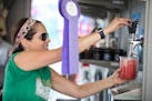 Sharon Hannigan, owner of the Produce Exchange, serves up some Fruit and Booch, watermelon spears with lemon kombucha. ] (Leila Navidi/Star Tribune) l