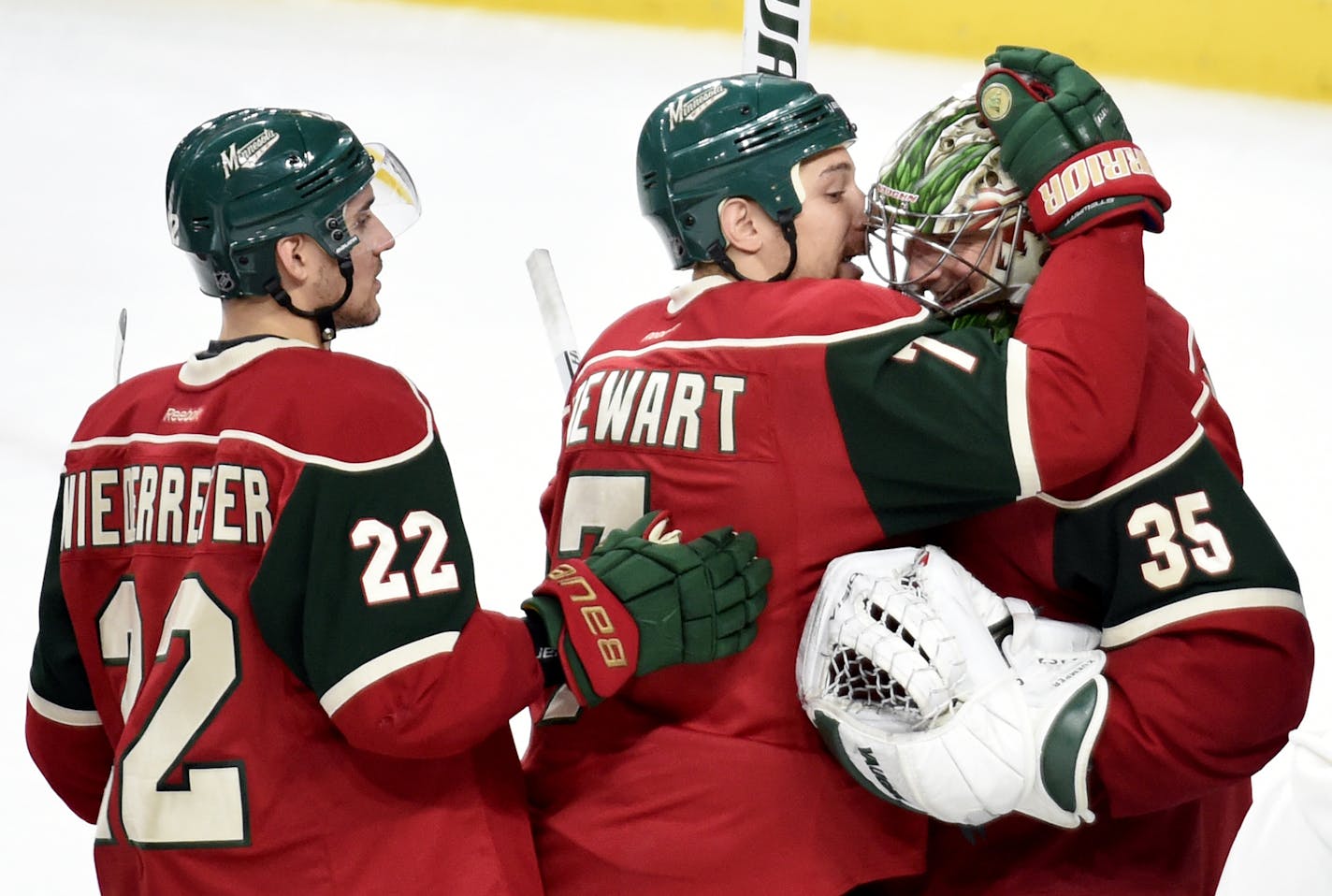 Minnesota Wild's Nino Niederreiter (22), of Switzerland, Chris Stewart (7) and goalie Darcy Kuemper (35) celebrate a win against the Arizona Coyotes after an NHL hockey game, Saturday, Dec. 17, 2016, in St. Paul, Minn. The Wild won 4-1. (AP Photo/Hannah Foslien)