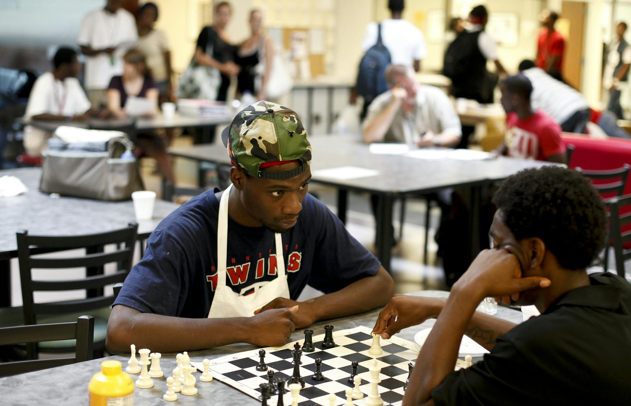 Chris Jacobz, 20, left, quickly glances at Johnnie Robinson, 19, during a chess game while they wait for dinner to be served in Minneapolis, Minn. on Monday, July 23, 2012. YouthLink is one of the vicinities in Twin Cities that offers showers, lockers, laundry service, child care, three meals a day, and resources and support for homeless teens.] MEGAN TAN/ STAR TRIBUNE‚Ä¢megan.tan@startribune.com.