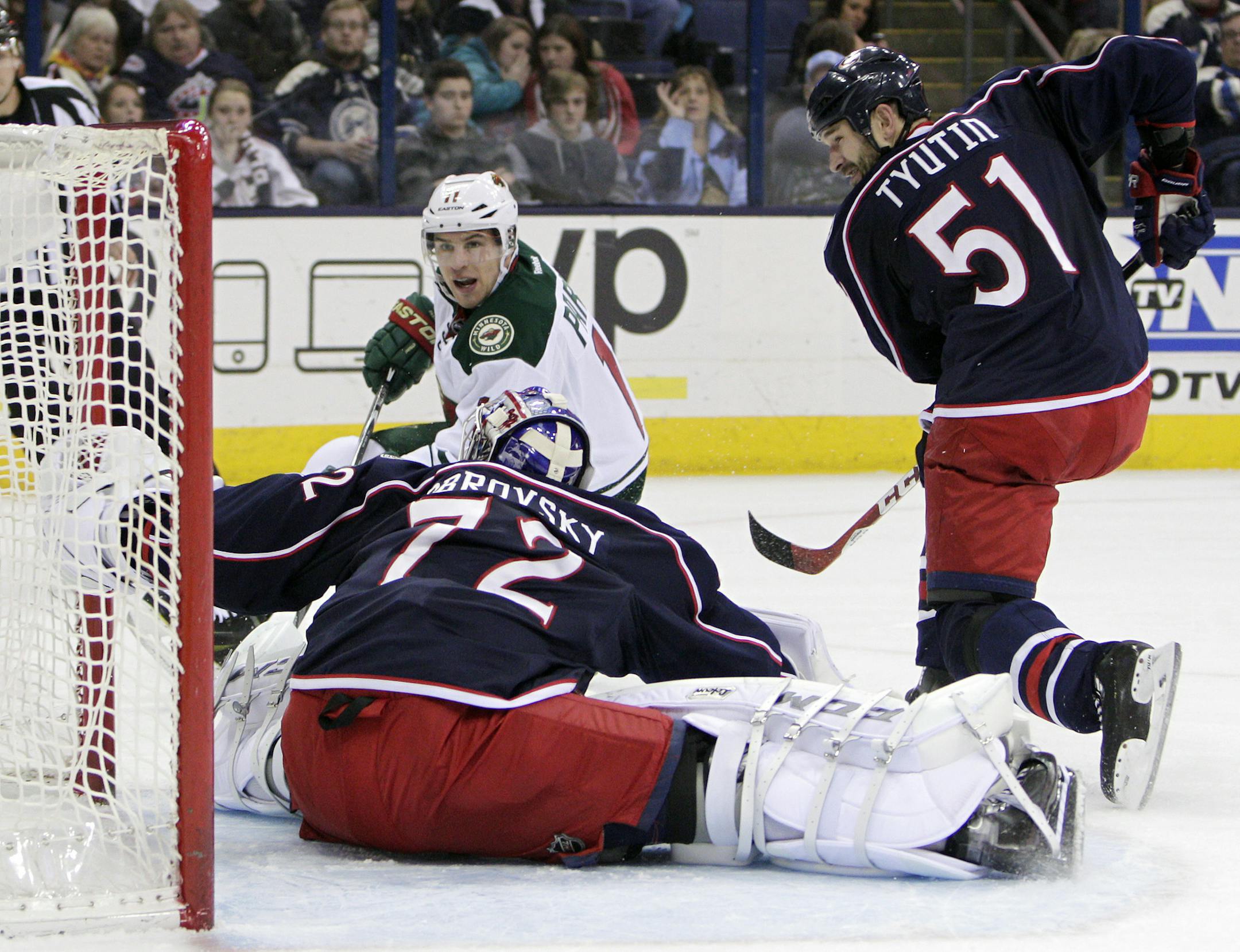 Minnesota Wild's Zach Parise, left, scores against Columbus Blue Jackets' Sergei Bobrovsky (72) of Russia, as Fedor Tyutin, of Russia, defends, during the first period of an NHL hockey game Wednesday, Dec. 31, 2014, in Columbus, Ohio. (AP Photo/Jay LaPrete)
