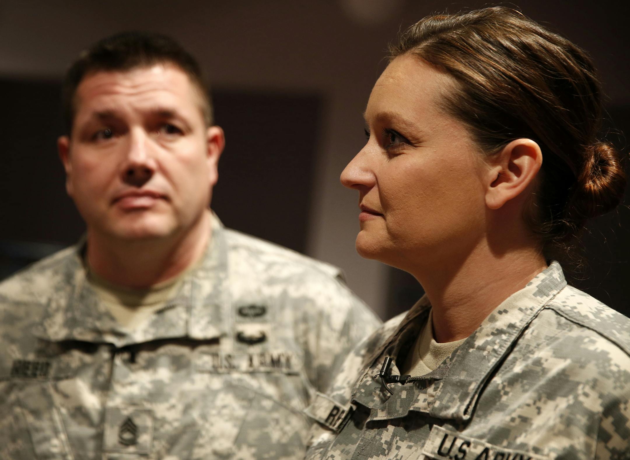 Sfc. Katy Reed, right, who will be mobilized with fellow Minnesota National Guard soldiers from the Rosemount-based 34th Red Bull Infantry Division to support humanitarian relief in Liberia in Spring 2015, attends a press conference at Rosemount National Guard Armory on Monday, November 17, 2014 . Her husband, left, Sfc. Chris Reed, will not be going to Liberia. ] LEILA NAVIDI leila.navidi@startribune.com /