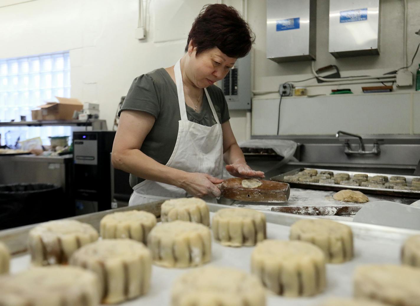 Pauline Kwan made mooncakes ahead of the lunar calendar harvest holiday that begins on Monday. Mooncakes are a specialty at the Mid-Autumn Festival and this is one of the only places in the Twin Cities where they are made. Here, Kwan, who has been making mooncakes for 35 years, stuffs the dough and filling into a wooden mold to form a moonlike before baking.