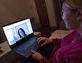 In this Jan. 14, 2019 photo, Caitlin Powers sits in the living room of her Brooklyn apartment in New York, and has a telemedicine video conference wit