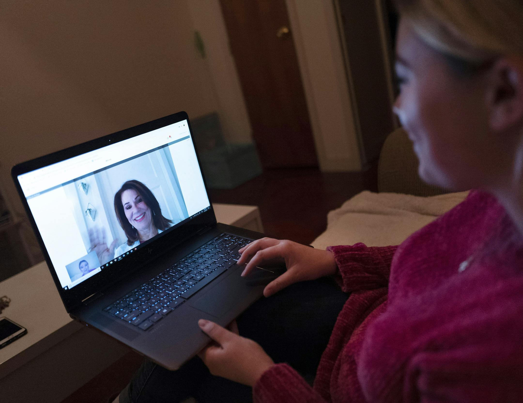 In this Jan. 14, 2019 photo, Caitlin Powers sits in the living room of her Brooklyn apartment in New York, and has a telemedicine video conference with physician, Dr. Deborah Mulligan. Widespread smartphone use, looser regulations and employer enthusiasm are helping to expand access to telemedicine, where patients interact with doctors and nurses from afar, often through a secure video connection. (AP Photo/Mark Lennihan) ORG XMIT: NYML402