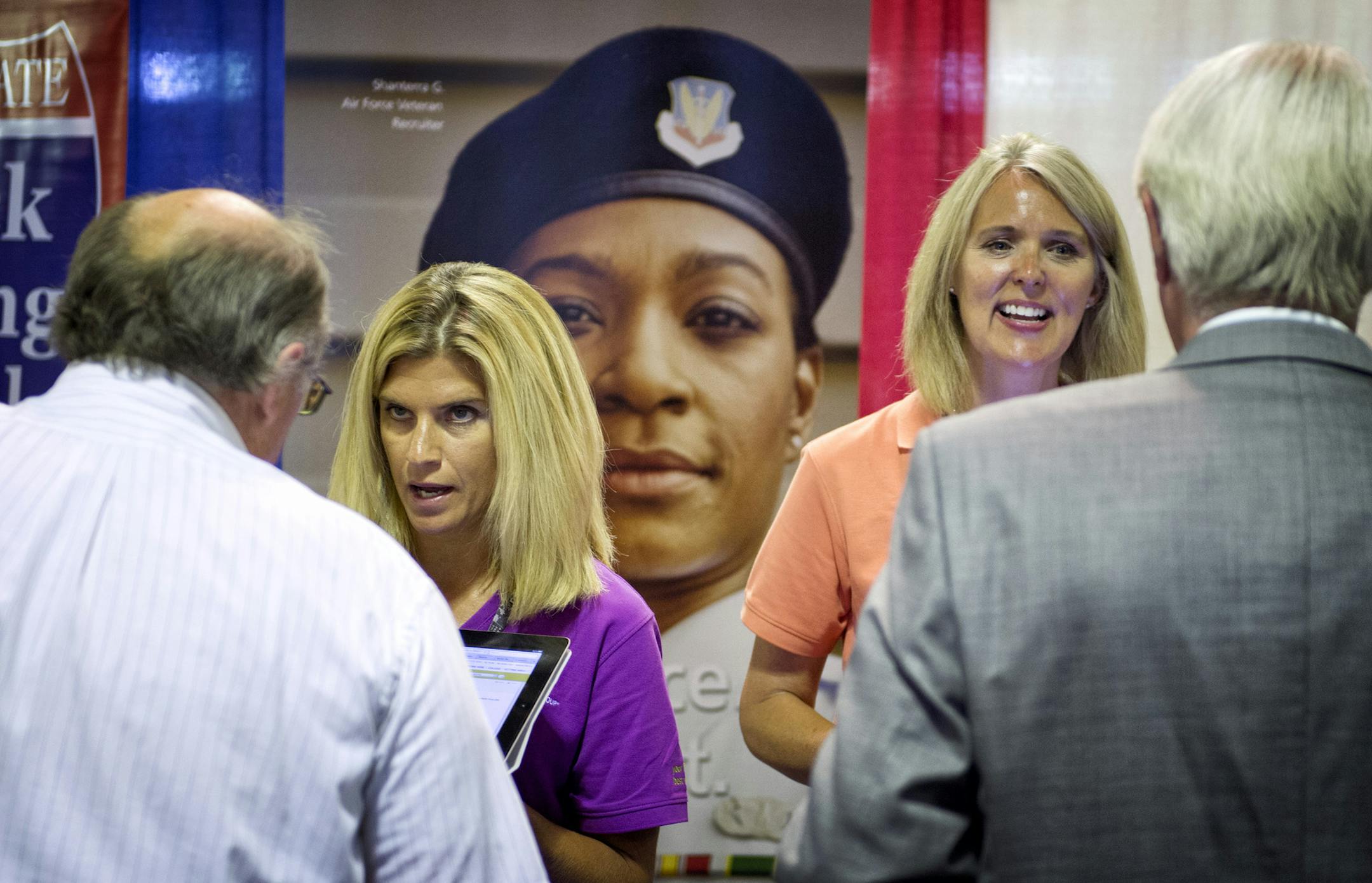 Lisa Starin, left, and Laura Johnson, recruiters for UnitedHealth Group, talked with job seekers at the veterans career fair. During Hire a Veteran Month, the Department of Employment and Economic Development sponsored Veterans Career Fair, held Tuesday.