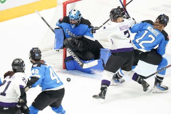 Toronto goaltender Kristen Campbell, center, makes a save as Minnesota's Claire Butorac battles with Toronto's Allie Munroe during the third period Fr