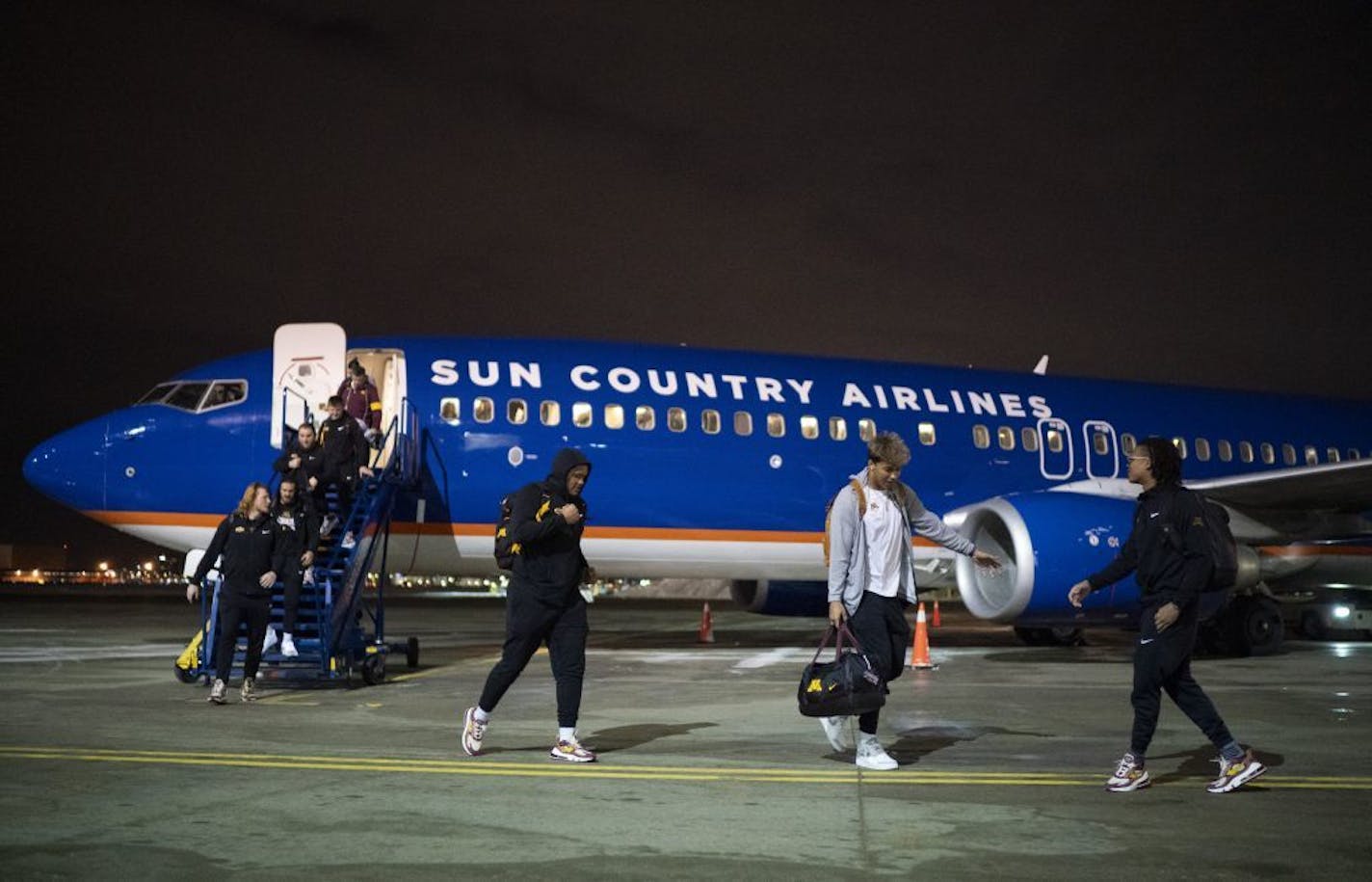 Gopher football players headed towards waiting busses after stepping off their charter flight Wednesday night.