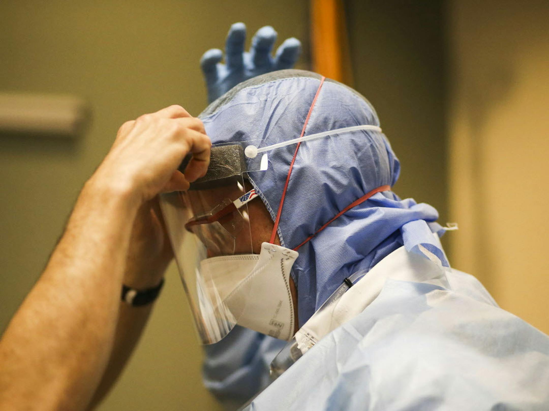 In this Tuesday, Oct. 28, 2014 photo, Pete Cheolis, an Allina EMT, gets help suiting up in personal protective equipment as Allina EMS first responders receive training on the latest protocol for handling future patients possibly infected with Ebola in Mounds View, Minn. Some first responders in the Twin Cities are tweaking and reinforcing protocols to be ready for Ebola if it hits the area. (AP Photo/The Star Tribune, David Joles)