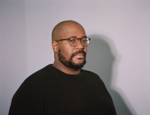 photo of author Brandon Taylor, with a dramatic shadow of his silhouette