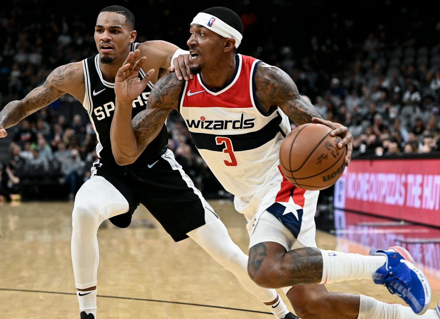 Washington Wizards' Bradley Beal (3) drives against San Antonio Spurs' Dejounte Murray during the first half of an NBA basketball game, Monday, Nov. 29, 2021, in San Antonio. (AP Photo/Darren Abate)