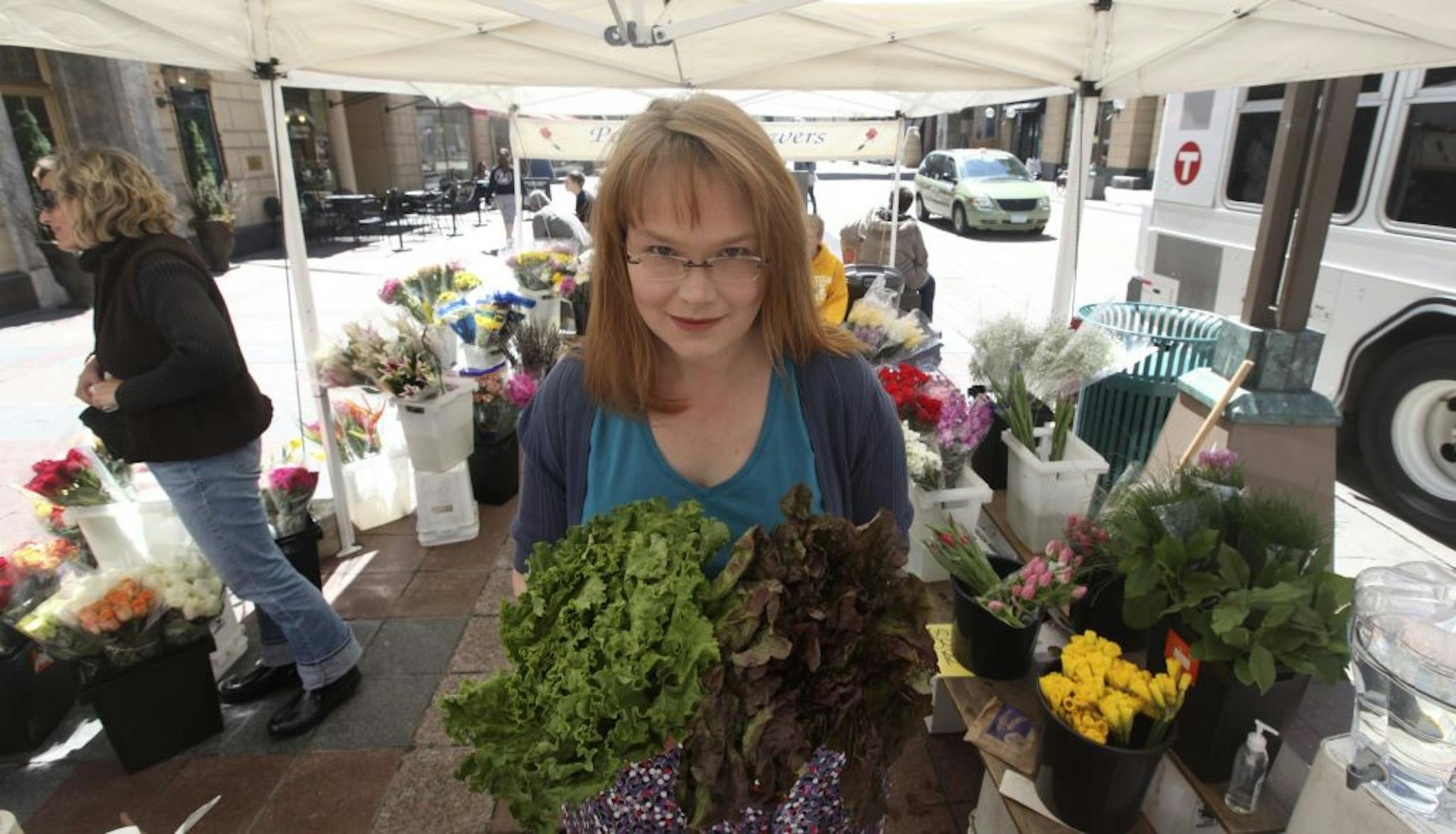 Tricia Cornell, author of Eat More Vegetables, " picked up two heads of some local lettuce being sold by Petersen's Flowers farm during the first day of the farmers' market on Nicollet Ave in Minneapolis, Min., Thursday, April 26, 2012.
