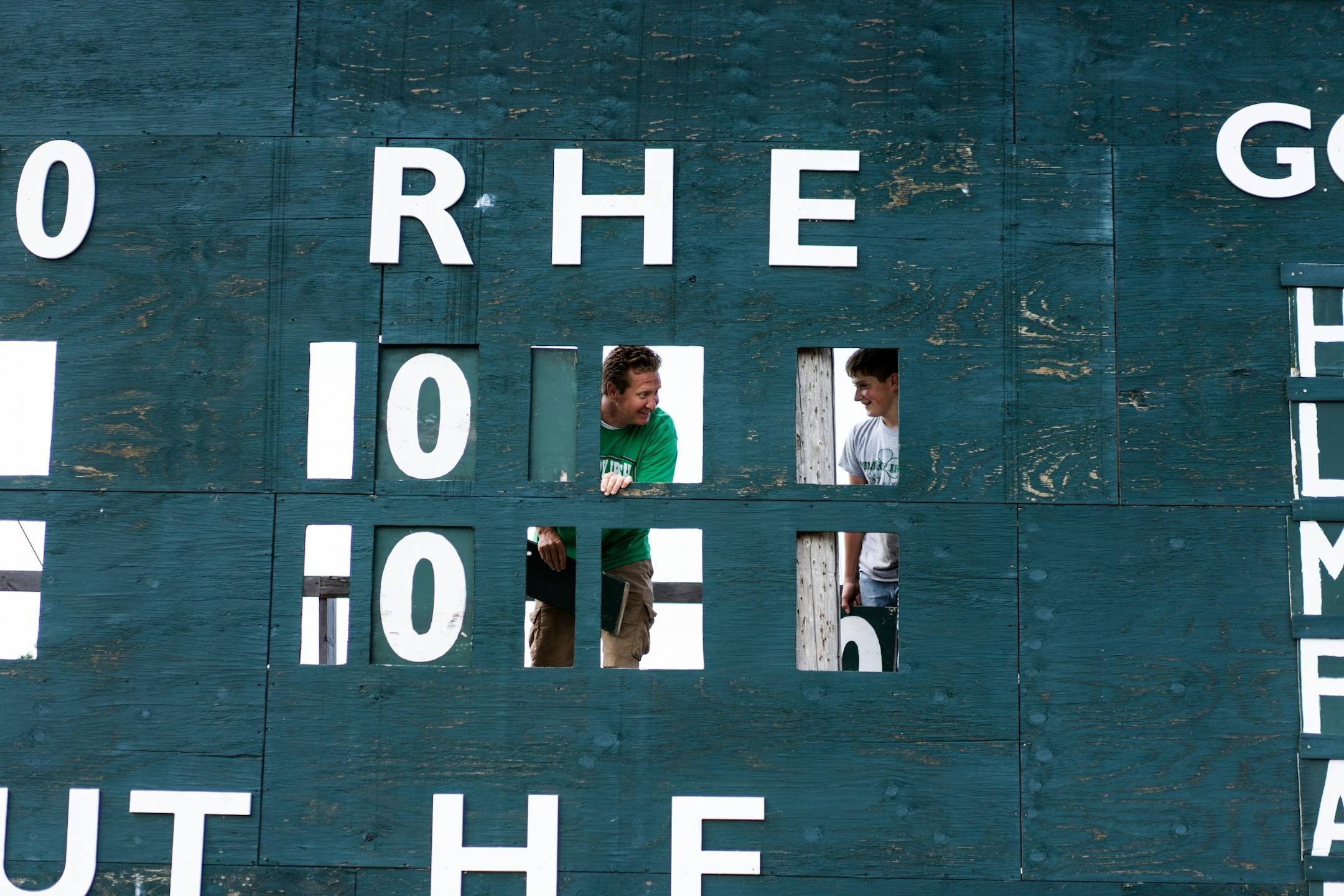 Milroy Irish manager Bob Dolan and his 14-year-old nephew Ezekiel Dolan replace numbers on the scoreboard at Irish Yard.