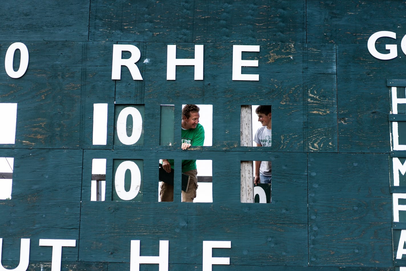 Milroy Irish manager Bob Dolan and his 14-year-old nephew Ezekiel Dolan replace numbers on the scoreboard at Irish Yard.