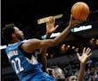 Minnesota Timberwolves' Andrew Wiggins, left, lays up a shot as he collides with Chicago Bulls' Bobby Portis in the second half of an NBA basketball g