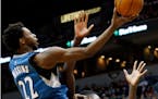 Minnesota Timberwolves' Andrew Wiggins, left, lays up a shot as he collides with Chicago Bulls' Bobby Portis in the second half of an NBA basketball g