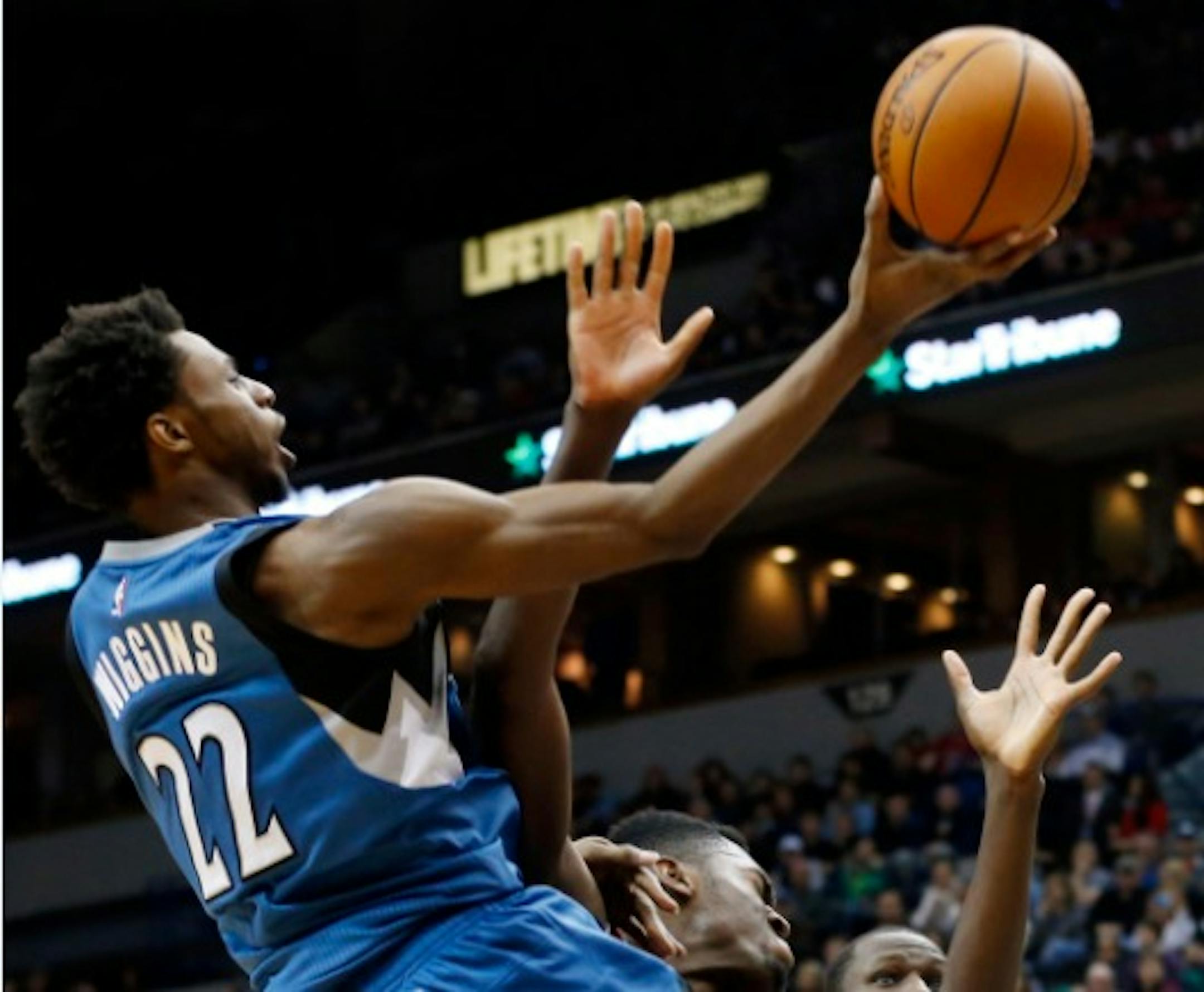 Minnesota Timberwolves' Andrew Wiggins, left, lays up a shot as he collides with Chicago Bulls' Bobby Portis in the second half of an NBA basketball game, Saturday, Feb. 6, 2016, in Minneapolis. The Timberwolves won 112-105. Wiggins scored 21 points. (AP Photo/Jim Mone)
