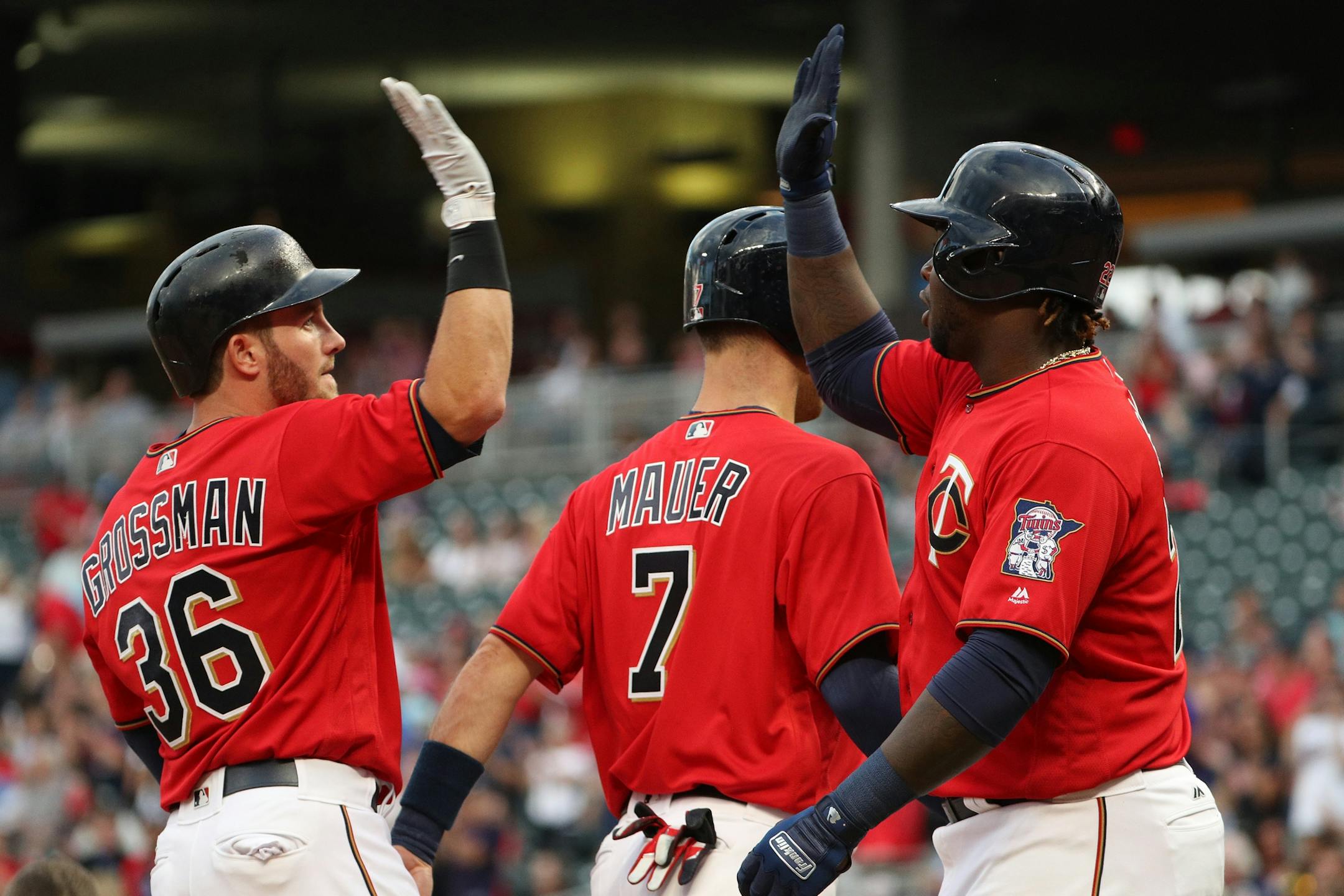 Minnesota Twins designated hitter Robbie Grossman (36) celebrated with Minnesota Twins first baseman Joe Mauer (7) and Minnesota Twins third baseman Miguel Sano (22) after hitting a home run allowing all three to score in the first inning.
