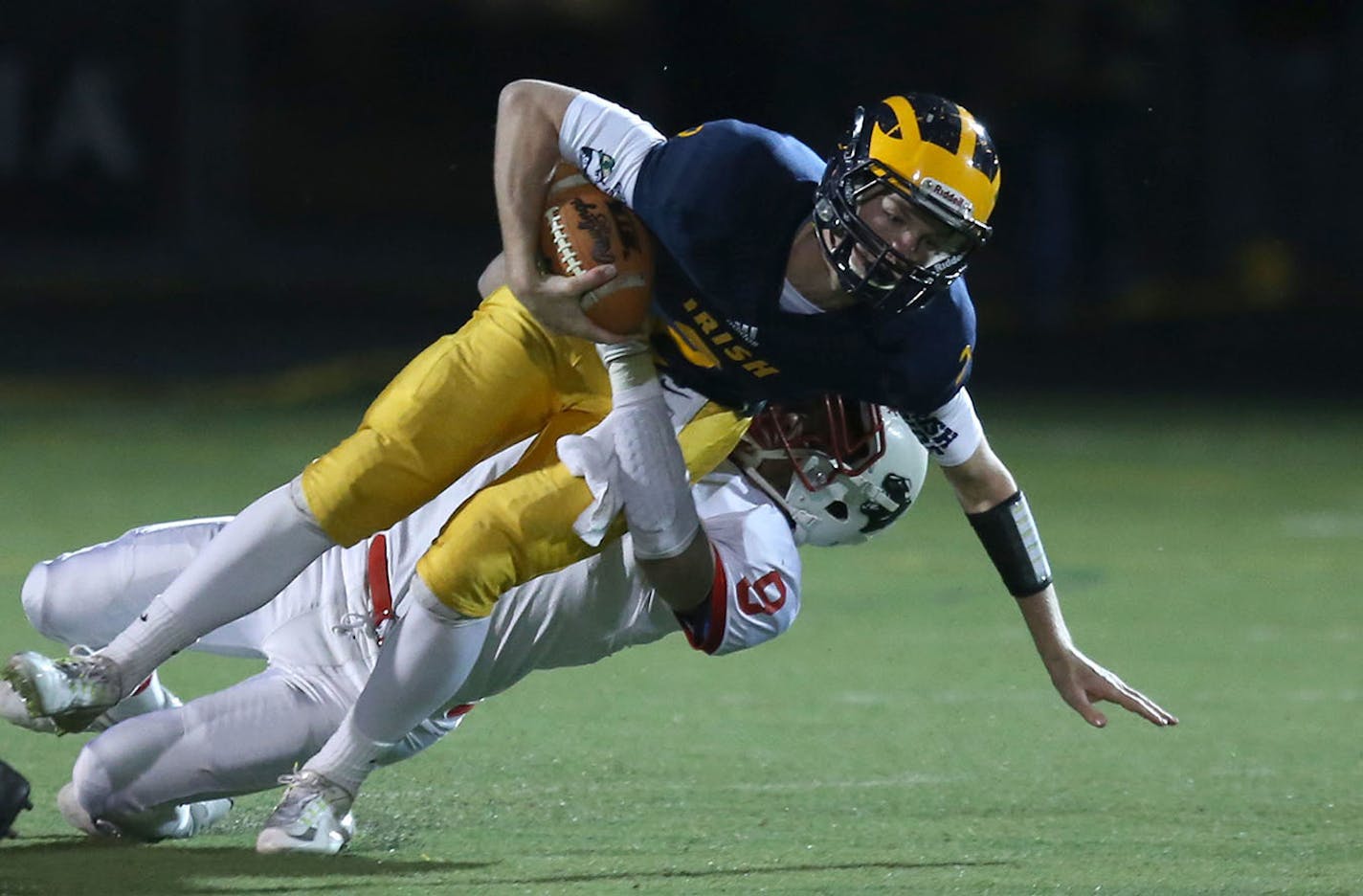 Rosemount's quarterback Jackson Erdmann got tackled by Lakeville North's Dakota Toedter and hurt his ankle during the first half. ] (KYNDELL HARKNESS/STAR TRIBUNE) kyndell.harkness@startribune.com Rosemount vs Lakeville North during the state quarterfinal game in Edina, Min., Thursday, November 6, 2014.