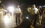 Police walk in the street during demonstrations in Ferguson, Mo., Aug. 11, 2015. Protests continued in Ferguson Tuesday night, two nights after bursts