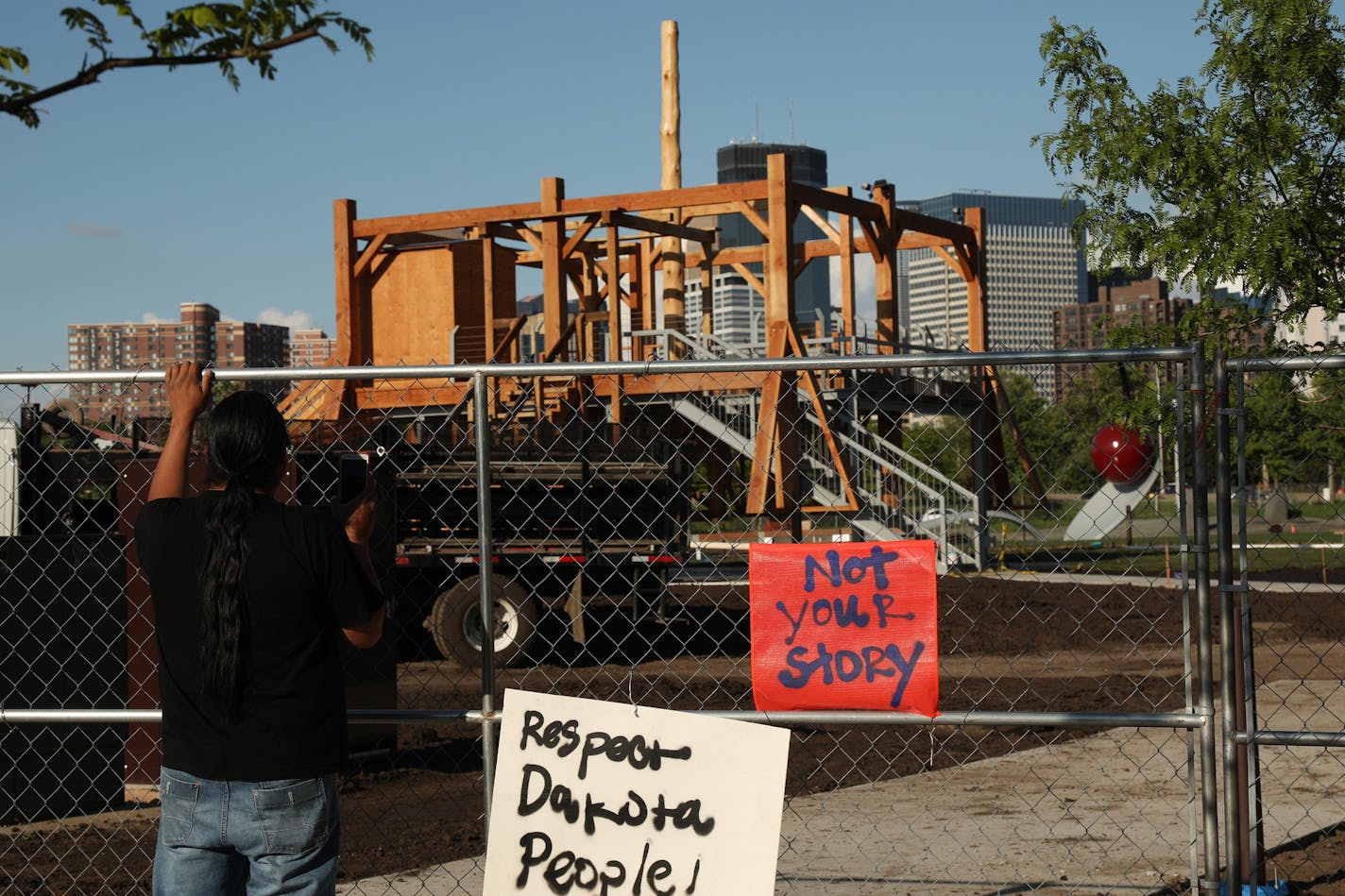 A man looked though the fence at "Scaffold" by Sam Durant at the Minneapolis Sculpture Garden.