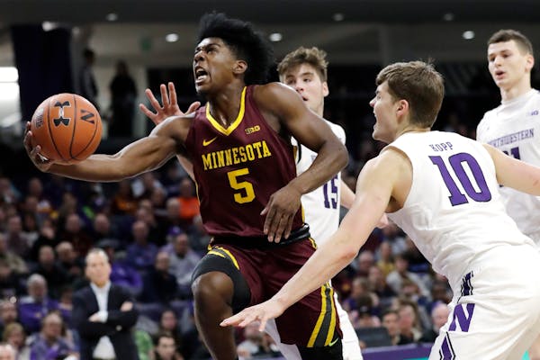 Gophers guard Marcus Carr drove to the basket past Northwestern forward Miller Kopp (10) and center Ryan Young during the first half in Evanston, Ill.