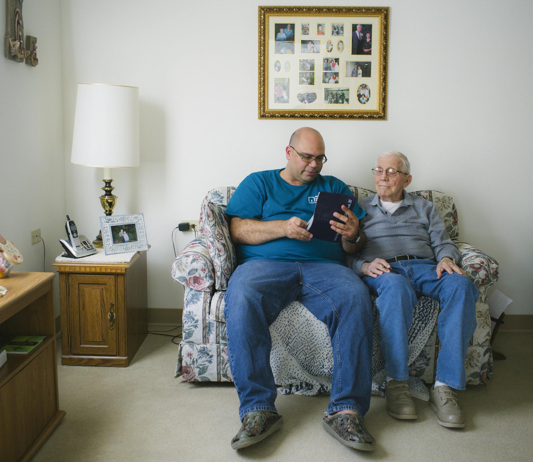 Gayle Snyder, 95, right, looks through his photo albums with his home caregiver Jeffrey Interiano in Zion, Ill., Oct. 22, 2015. While it is far preferable for retirees to remain at home as they age, the choices and costs can be daunting. (Taylor Glascock/The New York Times)