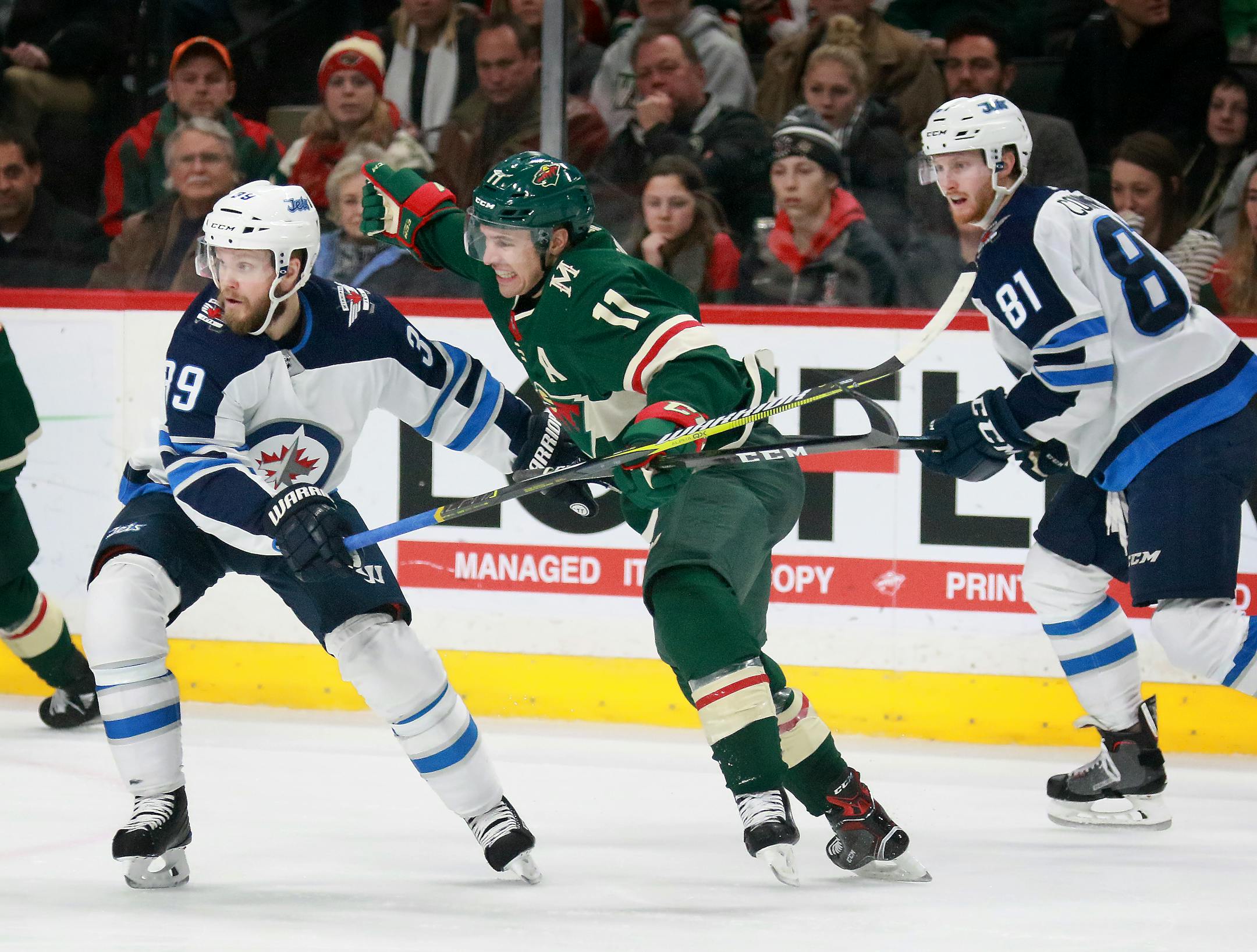The Wild's Zach Parise (11) is double teamed by Winnipeg's Toby Enstrom (39) and Kyle Connor (81)