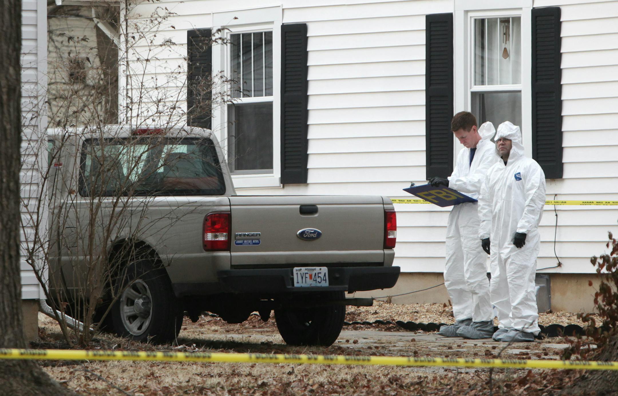Police and FBI agents investigate the scene where Craig Michael Wood was arrested in Springfield, Mo., on Wednesday, Feb. 19, 2014. Woods was charged Wednesday with first-degree murder in the death of a 10-year-old girl. A body believed to be that of Hailey Owens was found Wednesday at the home owned by Wood, Police Chief Paul Williams said at a news conference. Official confirmation won't occur until after an autopsy, but Police Chief Paul Williams said "we have a high degree of confidence" in