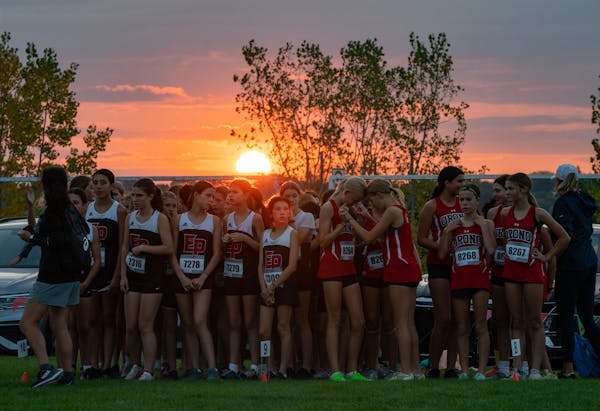 Middle school girls runners prepare to take off on a 2-mile race as the sun sets during the 58th Annual Metro Invitational Cross Country Meet Saturday